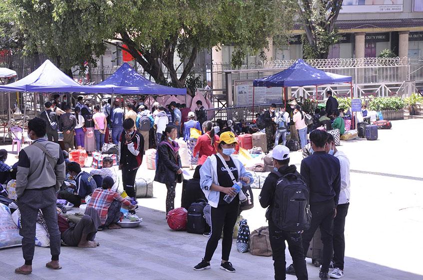 တရုတ်နိုင်ငံတွင် အလုပ်လုပ်ကိုင်ခဲ့သော မြန်မာရွှေ့ပြောင်းလုပ်သားများ မူဆယ်မြို့ နန်းတော်ဂိတ်သို့ ပြန်လည်ရောက်ရှိလာစဉ် (ဓာတ်ပုံ - ပြည့်စုံ)