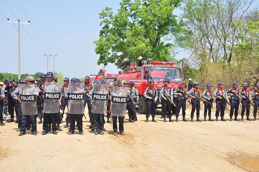 လမ်းပိတ်ဆို့မှုပြုလုပ်ထားသည့် ဒေသခံများကို ဖြိုခွဲရန် ရဲတပ်ဖွဲ့ဝင်များ လုံခြုံရေးရယူထားသည်ကို မေ ၁၅ ရက်က တွေ့ရစဉ် (ဓာတ်ပုံ - ဌေးလှအောင်)