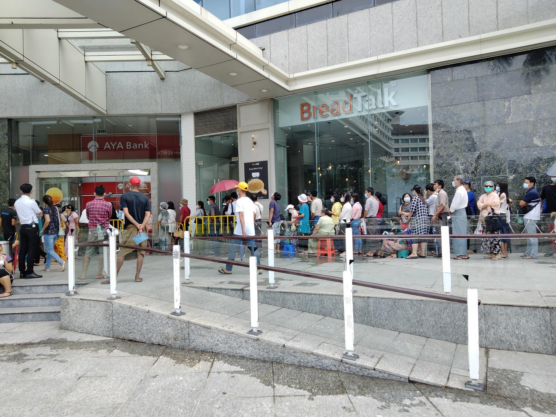 ရန်ကုန်မြို့ မြန်မာပလာဇာရှိ ATM စက်တစ်လုံးရှေ့တွင် ငွေထုတ်ရန်စောင့်ဆိုင်းနေသူများအား ဧပြီ ၃၀ ရက်က တွေ့ရစဉ် (ဓာတ်ပုံ-သီဟအောင်)