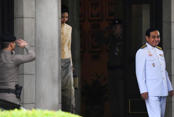 မတ် ၂၅ ရက်က ဘန်ကောက်ရှိ အစိုးရရုံး အဆောက်အအုံမှ ထွက်လာသော ထိုင်းဝန်ကြီးချုပ် ပရာယွတ်ချန်အိုချာ(ယာ)နှင့် ဇနီးတို့အား တွေ့ရစဉ် (Photo: AFP)