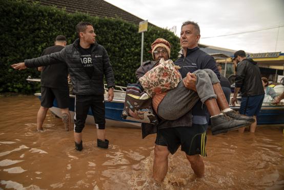 မေ ၄ ရက်က ဘရာဇီးနိုင်ငံ ရီယို ဂရန်ဒီ ဒိုဆူလ်ပြည်နယ်တွင် ရေလွှမ်းမိုးနေသည့်နေရာမှ ဒေသခံများက ဘေးလွတ်ရာ ပြောင်းရွှေ့နေစဉ်