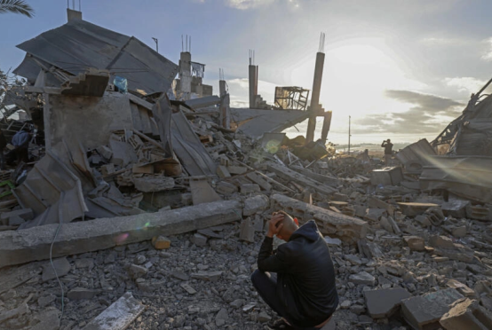 အစ္စရေးတိုက်ခိုက်မှုကြောင့် ရာဖာ၌ ပျက်စီးနေသည်များကို ပါလက်စတိုင်းအမျိုးသားတစ်ဦး ထိုင်ကြည့်နေပုံကို ဖေဖော်ဝါရီ ၂၂ ရက်တွင် တွေ့ရစဉ်(Photo: AFP)
