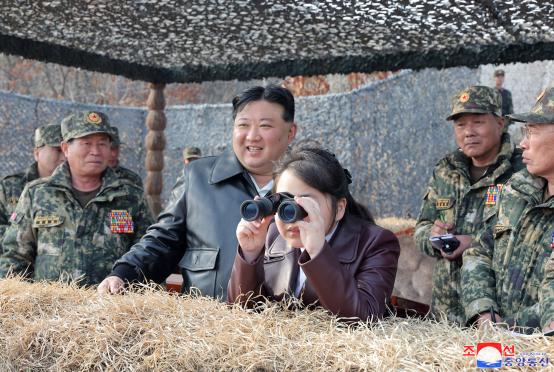 မတ် ၁၅ ရက်က မြောက်ကိုရီးယား၏ အမည်ဖော်ပြမထားသည့် နေရာတွင် စစ်ရေးလေ့ကျင့်မှုများကို ကြည့်ရှုနေသည့် ကင်ဂျုံအွန်(လယ်-ဝဲ)နှင့် ၎င်း၏သမီးဖြစ်သူ ကင်ဂျူအဲ(လယ်-ယာ)တို့ကို တွေ့ရစဉ်(Photo: AFP)