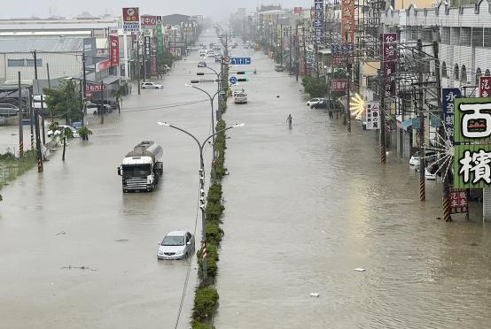 ဇူလိုင် ၂၅ ရက်က ကောင်းရှောင်မြို့တွင် တိုင်ဖွန်းဂယ်မီ တိုက်ခတ်မှုကြောင့် လမ်းပေါ်တွင် ရေလွှမ်းမိုးမှုဖြစ်ပွားနေစဉ်(Photo: AFP)