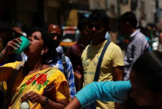 ဧပြီ ၂၄ ရက်က အိန္ဒိယနိုင်ငံ ဘန်ဂလာရူးမြို့၌ အပူလှိုင်းကျစဉ် အမျိုးသမီးတစ်ဦး ဒိန်ချဉ်သောက်နေပုံကို တွေ့ရစဉ်(Photo: Reuters)