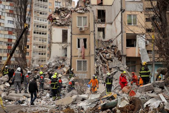 မတ် ၂ ရက်က အိုဒက်ဆာမြို့တွင် ရုရှား၏ ဒရုန်းတိုက်ခိုက်မှုကြောင့် ပြိုကျပျက်စီးနေသည့် လူနေအဆောက်အအုံတစ်ခုရှေ့တွင် ကယ်ဆယ်ရေးသမားများကို တွေ့ရစဉ်