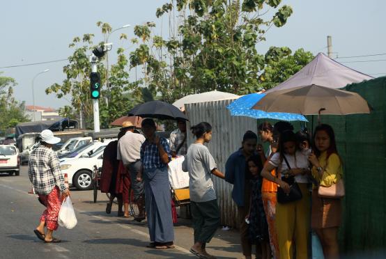 ရန်ကုန်မြို့၏ နေ့အပူချိန်တွင် သွားလာနေသူအချို့ကို တွေ့ရစဉ် (ဓာတ်ပုံ-ကြည်နိုင်)