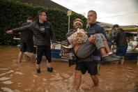 မေ ၄ ရက်က ဘရာဇီးနိုင်ငံ ရီယို ဂရန်ဒီ ဒိုဆူလ်ပြည်နယ်တွင် ရေလွှမ်းမိုးနေသည့်နေရာမှ ဒေသခံများက ဘေးလွတ်ရာ ပြောင်းရွှေ့နေစဉ်