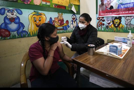 ဇန်နဝါရီ ၂၀ ရက်က အိန္ဒိယနိုင်ငံ နယူးဒေလီမြို့တော်ရှိ အစိုးရစာသင်ကျောင်းတစ်ကျောင်းတွင် ကျန်းမာရေးဝန်ထမ်းတစ်ဦးက ကာကွယ်ဆေးထိုးနှံပေးနေစဉ် Photo:AP
