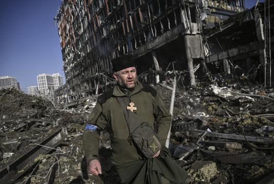 မတ်လ ၂၁ ရက်က ရုရှား၏ တိုက်ခိုက်မှုအပြီးတွင် ယူကရိန်းနို်င်ငံ ကိယက်ဗ်မြို့ရှိ အဆောက်အအုံ အပျက်အစီးများကြားမှ ယူကရိန်းစစ်သားတစ်ဦးကို တွေ့ရစဉ် (Photo : AFP)