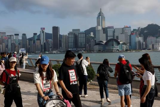 မေ ၂ ရက်က ဟောင်ကောင်ဒေသရှိ Tsim Sha Tsui အရပ်တွင် တရုတ်ပြည်မမှ အလည်အပတ်လာရောက်သည့် ခရီးသွားများကိုတွေ့ရစဉ် (Photo – Reuters)