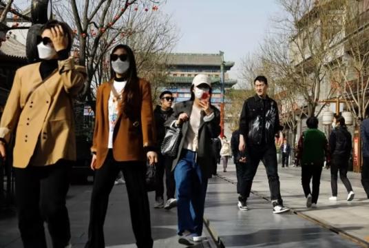 မတ်လ ၁၄ ရက်က တရုတ်နိုင်ငံ ပေကျင်းမြို့ ချန်မန်လမ်းရှိ ခရီးသွားများလာရောက်ရာ နေရာတစ်ခုတွင် လမ်းလျှောက်နေသူများကိုတွေ့ရစဉ် (Photo – Reuters)