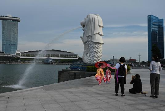 အောက်တိုဘာ ၁၃ ရက်က စင်ကာပူနိုင်ငံရှိ Merlion ရုပ်တုရှေ့တွင် ဓာတ်ပုံရိုက်နေသော မိန်းကလေးများကို တွေ့ရစဉ်