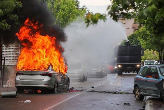 မေ ၂၆ ရက်က ကိုဆိုဗိုတွင် မီးလောင်နေသည့် ကားတစ်စီးကို မီးသတ်ပိုက်ဖြင့်ငြိှမ်းသတ်ရန် ကြိုးပမ်းနေစဉ် (Photo – AFP)
