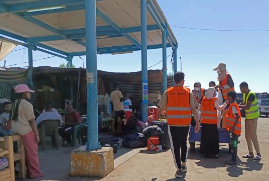 မေ ၂ ရက်က အီဂျစ်နိုင်ငံအက်စ်ဝမ်မြို့အနီးရှိ ၀ါဒီကာကာဘတ်စ်ကားဂိတ်တွင် ဆူဒန်နိုင်ငံမှ ထွက်ပြေးလာသူများအတွက် ပရဟိတသမားများက အကူအညီပေးရေးအထုတ်များကို ပြင်ဆင်နေစဉ်  (Photo – AFP)