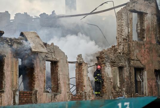 မေ ၂၆ ရက်က နီပရိုမြို့တွင် ဒုံးကျည်ထိမှန်မှုကြောင့် ပျက်စီးသွားသည့် ဆေးဘက်ဆိုင်ရာ အဆောက်အအုံတစ်ခုကို မီးသတ်ဝန်ထမ်းတစ်ဦးက စစ်ဆေးနေစဉ် (Photo – AFP)