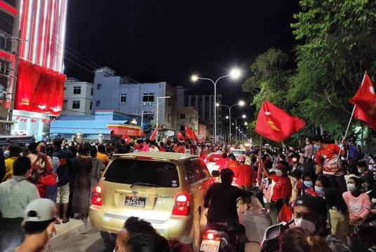 မန္တလေးမြို့ အမျိုးသား ဒီမိုကရေစီအဖွဲ့ချုပ် ရုံးရှေ့တွင် NLD ပါတီ ထောက်ခံသူများ အောင်ပွဲခံနေသည်ကို နိုဝင်ဘာ ၈ ရက် ညပိုင်းက တွေ့ရစဉ်