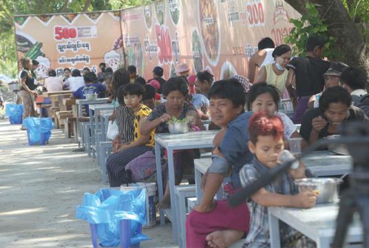 မြောက်ဒဂုံမြို့နယ်၌ ဖွင့်လှစ်ထားသော ကျပ်ငါးရာတန် ဇလုံထမင်းနှင့် ကျပ်ငါးရာတန်ဈေးတန်းတွင် စားသုံးနေသူများကို တွေ့ရစဉ် (ဓာတ်ပုံ-သီဟအောင်)