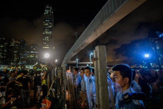 ဇွန် ၂၈ ရက်က ဟောင်ကောင်မြို့ ၀ိတိုရိယဆိပ်ကမ်း တစ်လျှောက် စုဝေးနေကြသည့် ဆန္ဒပြသူများကို ရဲတပ်ဖွဲ့က ဝိုင်းရံထားစဉ် (Photo: AFP)