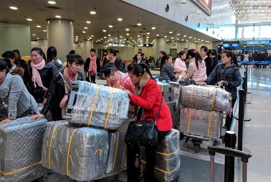 ပေကျင်းလေဆိပ်တွင် ပြုံယမ်းသို့ပြန်မည့် လေယာဉ်ခရီးစဉ်ကို တန်းစီစောင့်ဆိုင်းနေကြသော မြောက်ကိုရီးယား အလုပ်သမားများကို မတ်လအတွင်းက တွေ့ရစဉ် (Photo : AFP)