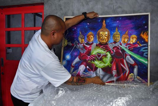  စက်တင်ဘာ ၁၂ ရက်တွင် ဘန်ကောက်ရှိ နေအိမ်၌ ပန်းချီကားစုဆောင်းသူ Pakorn Porncheewangkul က အငြင်းပွားဖွယ် ပန်းချီကားအား နေရာချနေစဉ်