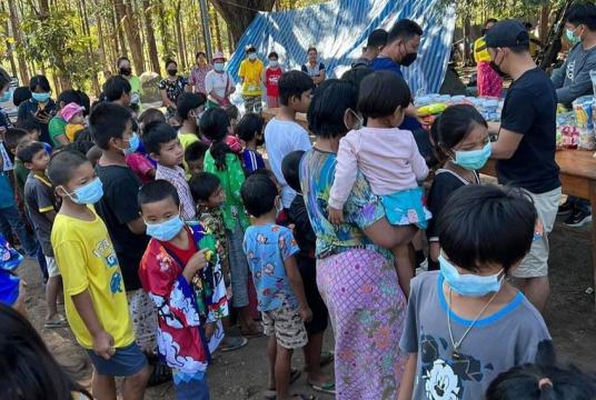 စစ်ဘေးရှောင်နေရသည့် ကျောင်းနေအရွယ်ကလေးငယ်များနှင့် ၎င်းတို့၏အုပ်ထိန်းသူများအား လူမှုအကူအညီပေးနေသူများက ပစ္စည်းများ ထောက်ပံ့နေသည်ကို ထိုင်းနိုင်ငံဘက်ခြမ်းတွင် တွေ့ရစဉ် (ဓာတ်ပုံ-ကိုကြီးမန်း)