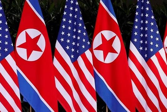 ၂၀၁၈ ခုနှစ် ဇွန်လ ၁၂ ရက်က စင်ကာပူနိုင်ငံ ဆန်တိုဆာကျွန်းရှိ Capella ဟိုတယ်တွင် အမေရိကန်နှင့် မြောက်ကိုရီးယားအလံ လွှင့်ထူထားပုံကို တွေ့ရစဉ် (Photo – AFP)