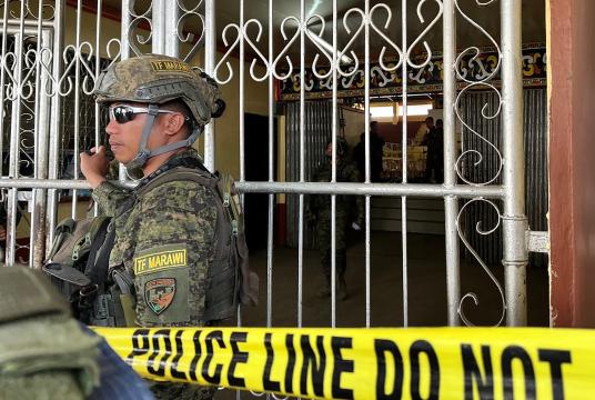 ဒီဇင်ဘာ ၃ ရက်က ဖိလစ်ပိုင်နိုင်ငံ မာရာဝီမြို့ရှိ ဗုံးပေါက်ကွဲမှုဖြစ်ပွားခဲ့သည့် တက္ကသိုလ်အားကစားရုံ ဝင်ပေါက်တွင် ဖိလစ်ပိုင်တပ်ဖွဲ့ဝင်တစ်ဦး စောင့်ကြပ်နေစဉ်(Photo: AFP)