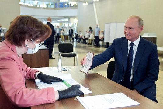 ရုရှားသမ္မတ ပူတင်က မော်စကို၏ မဲရုံတစ်ရုံတွင် ဇူလိုင် ၁ ၌ မဲရုံဝန်ထမ်းအား ၎င်း၏နိုင်ငံကူးလက်မှတ်ကို ပြသနေစဉ်