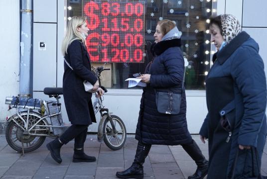 ဖေဖော်ဝါရီ ၂၈ ရက်က မော်စကိုမြို့တွင် ရုရှားရူဘယ်နှင့် အမေရိကန်ဒေါ်လာ၊ ယူရိုငွေတို့ လဲလှယ်နှုန်းကို ပြသထားသော ငွေလဲလှယ်သည့် ရုံးတစ်ခုကို လူများ ဖြတ်လျှောက်သွားကြစဉ် ( Photo-AP)