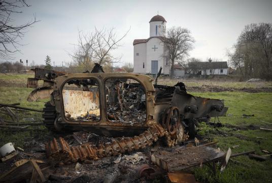 ဧပြီ ၁၁ ရက်က ကိဗ်မြို့အနီး လစ်ပစ်ကာရွာရှိ ခရစ်ယာန်ဘုရားကျောင်းနောက်ခံ၌ ပျက်စီးနေသော ရုရှားစစ်ယာဉ်တစ်စီး၏ အပိုင်းအစများကို တွေ့ရစဉ် (Photo:AP)