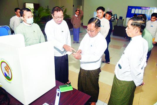 မြန်မာအီလက်ထရွန်နစ် မဲပေးစက်နှင့်စပ်လျဉ်း၍ ရှင်းလင်းပြသခြင်းနှင့် လက်တွေ့သရုပ်ပြစမ်းသပ်မဲပေးခြင်းကို သြဂုတ် ၁၄ ရက်က နေပြည်တော်ရှိ  ပြည်ထောင်စုအစိုးရအဖွဲ့ရုံးဝန်ကြီးဌာန အစည်းအဝေးခန်းမ၌ ပြုလုပ်စဉ်
