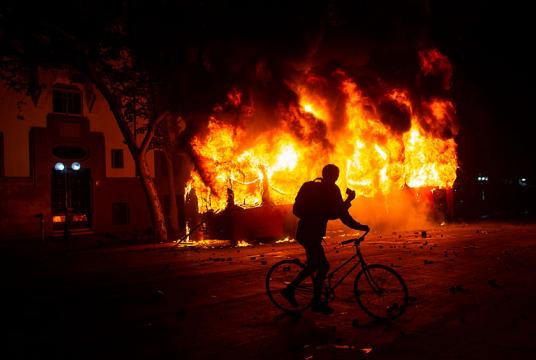 အောက်တိုဘာ ၁၈ ရက်တွင် ဆန်တီယေဂိုမြို့၌ ဆန္ဒပြမှုအတွင်းဘတ်စ်ကားတစ်စီး မီးရှို့ခံထားရစဉ် (Photo: AFP)