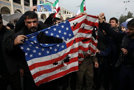 ဇန်နဝါရီ ၃ ရက်က တီဟီရန်မြို့တွင် ဆိုလေမာနီကို သတ်ဖြတ်မှုအား ဆန့်ကျင်သည့် ဆန္ဒပြပွဲအတွင်း အမေရိကန်အလံကို မီးရှို့နေစဉ် (Photo : AP)