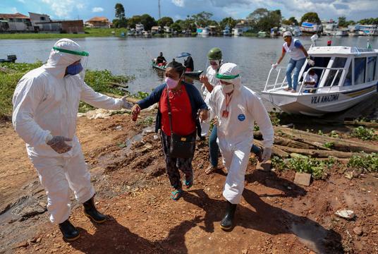 ဘရာဇီး၏ Amazonas ပြည်နယ်မှ လူနာတင်သင်္ဘောနှင့် ရောက်လာသူများအား ကျန်းမာရေးဝန်ထမ်းများက ကူညီနေစဉ် (Photo: AP)
