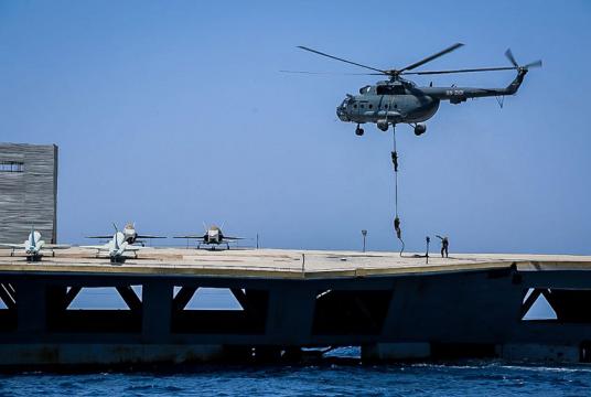 ရုရှားလုပ် အီရန်စစ်ဘက်ရဟတ်ယာဉ်တစ်စင်းမှ စစ်သားများက ဇူလိုင် ၂၈ တွင် အမေရိကန်လေယာဉ်တင် သင်္ဘောပုံစံတူ သင်္ဘောပေါ်သို့ ဆင်းနေမှုကို တွေ့ရစဉ် (Photo:AFP)