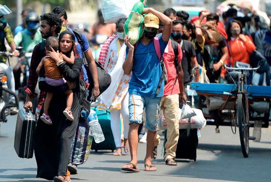 မေ ၃၀ ရက်က ချန်နိုင်းမြို့၌ ဘီဟာသို့သွားရန် ဘူတာရုံသို့ လမ်းလျှောက်သွားနေသည့် ရွှေ့ပြောင်းအလုပ်သမားများကို တွေ့ရစဉ် (Photo: AFP)