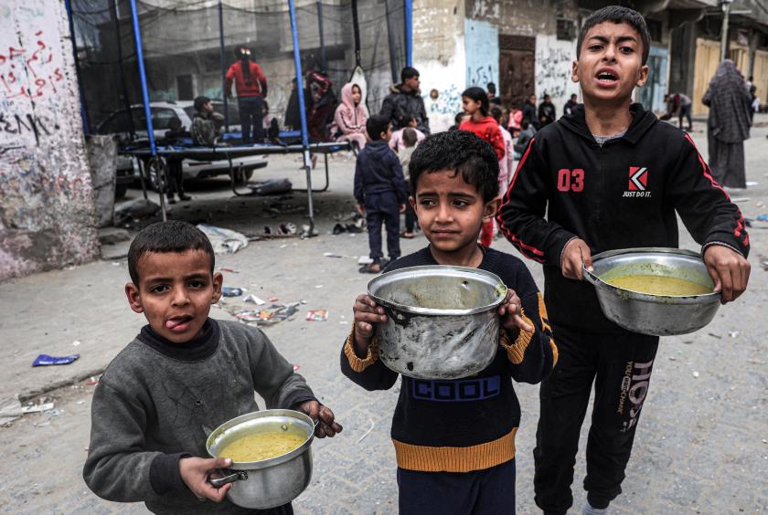 မတ် ၁၆ ရက်က ရာဖာမြို့တွင် ပရဟိတအဖွဲ့တစ်ဖွဲ့က ထောက်ပံ့ပေးသည့် စားစာရာများကို အိုးများနှင့်ထည့်ပြီး ယူဆောင်လာသည့် ပါလက်စတိုင်းကလေးများကို တွေ့ရစဉ်(Ref:Reuters)