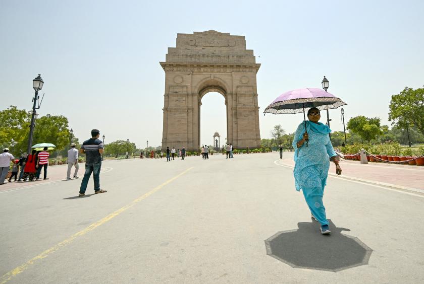 မေ ၂၉ ရက်က အိန္ဒိယနိုင်ငံ နယူးဒေလီမြို့တော်ရှိ အိန္ဒိယဂိတ်တံခါးအနီး ထီးစောင်း၍ လမ်းလျှောက်နေသူ အမျိုးသမီးတစ်ဦးကို တွေ့ရစဉ်(Photo:AFP)
