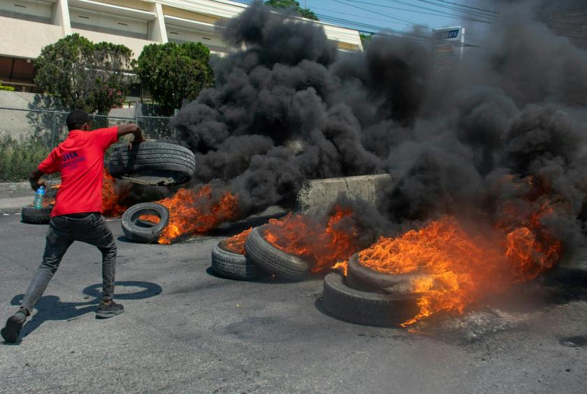 မတ် ၁၂ ရက်က ပို့အော်ပရင့်စ်မြို့တော်တွင် ဝန်ကြီးချုပ်အားဆန့်ကျင်သည့် ဆန္ဒပြသူတစ်ဦးက လမ်းပေါ်တွင် တာယာများကို မီးရှို့နေစဉ်