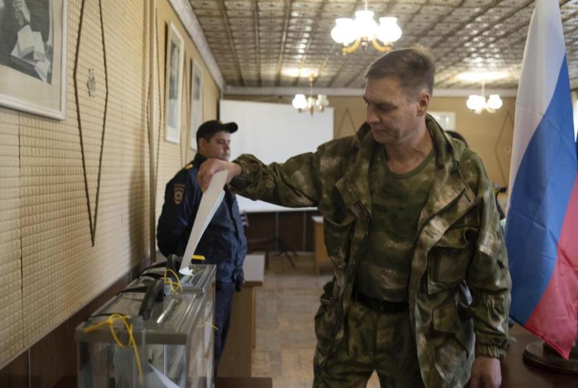ရုရှားကျောထောက်နောက်ခံပြု ခွဲထွက်ရေးသမားများ ထိန်းချုပ်ထားသည့် လူဟန့်ဒေသရှိ မဲရုံတစ်ရုံတွင် ဒေသခံတပ်ဖွဲ့ဝင်တစ်ဦး မဲပေးနေပုံကို စက်တင်ဘာ ၂၃ ရက်က တွေ့ရစဉ် (Photo : AFP)