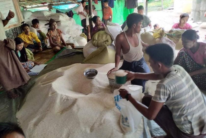 မြေပုံမြို့နယ်ရှိ စစ်ဘေးရှောင်စခန်း တစ်ခုတွင် ရိက္ခာများကို ခွဲဝေးပေးနေစဉ်