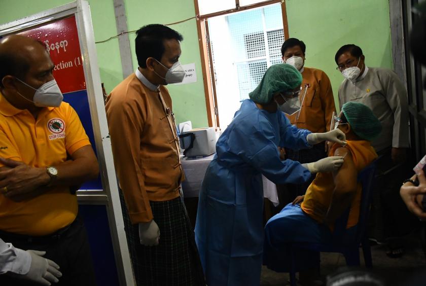 ရန်ကုန်တိုင်းဒေသကြီးတွင် ပထမဦးဆုံး ကိုဗစ်ကာကွယ်ဆေးထိုးပေးခြင်းခံရသည့် ရန်ကုန်ဆေးရုံကြီးမှ သူနာပြုအုပ်ကြီး အား COVID-19 ကာကွယ်ဆေး စတင်ထိုးနှံနေစဉ်  ဓာတ်ပုံ- ကြည်နိုင်