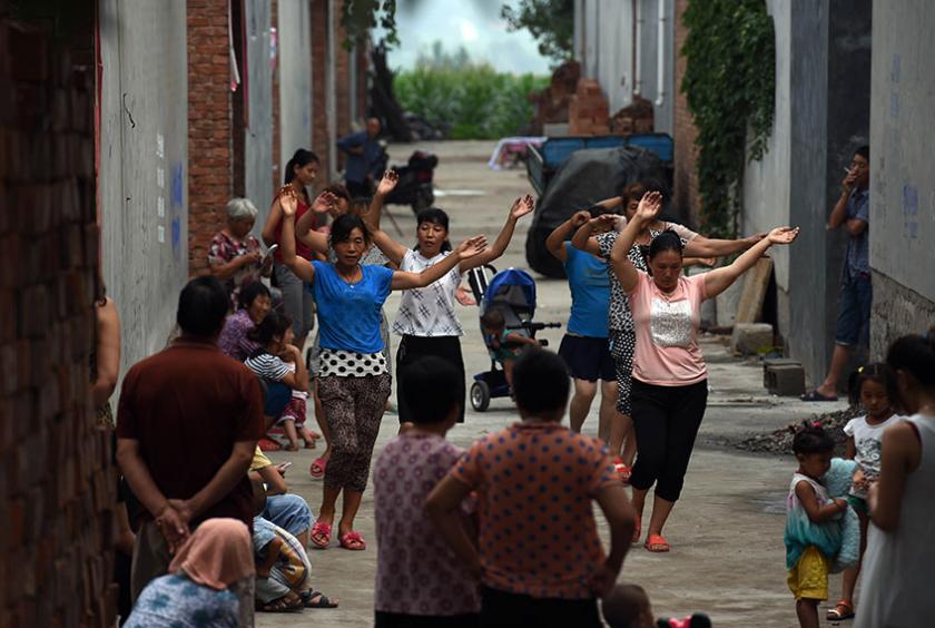 ၂၀၁၄ ခုနှစ် ဇူလိုင် ၃၀ ရက်တွင် တရုတ်နိုင်ငံ ဟီနန်ပြည်နယ်၌ နံနက်အစောပိုင်းတွင် အမျိုးသမီးတစ်စုက လေ့ကျင့်ခန်း ပြုလုပ်နေကြစဉ် (Photo : AFP)