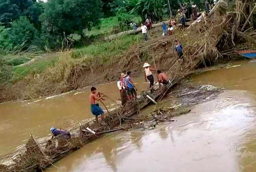ပျက်စီးသွားသော ကြိုးတံတားမှ အမှိုက်နှင့်ဒိုက်များကို ဒေသခံများက ဖယ်ရှားနေကြစဉ် (ဓာတ်ပုံ- ကိုဝင်းနိုင်)