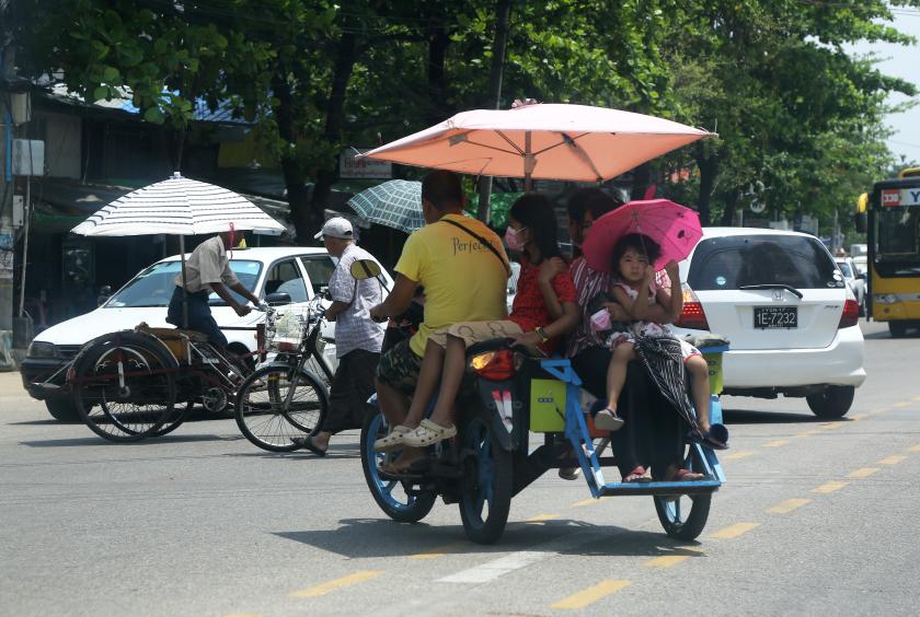 ရန်ကုန်မြို့၏ နေ့အပူချိန်တွင် သွားလာနေသူများကို မေ ၂၇  ရက်က တွေ့ရစဉ် (ဓာတ်ပုံ-ကြည်နိုင်)