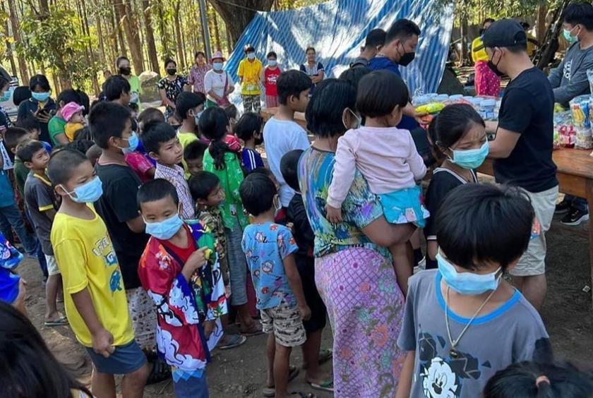စစ်ဘေးရှောင်နေရသည့် ကျောင်းနေအရွယ်ကလေးငယ်များနှင့် ၎င်းတို့၏အုပ်ထိန်းသူများအား လူမှုအကူအညီပေးနေသူများက ပစ္စည်းများ ထောက်ပံ့နေသည်ကို ထိုင်းနိုင်ငံဘက်ခြမ်းတွင် တွေ့ရစဉ် (ဓာတ်ပုံ-ကိုကြီးမန်း)