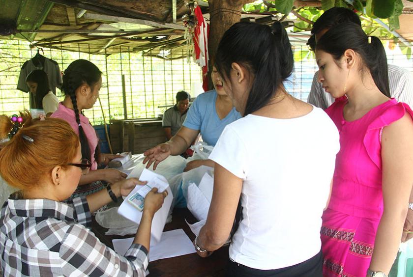 ပုံစာ - (လှိုင်သာယာစက်မှုဇုန် (၂) ရှိ လက်ဝါး အထည်ချုပ်စက်ရုံ ၃ ပိတ်သိမ်းသဖြင့် အလုပ်သမားများအား နစ်နာကြေး ပေးနေသည်ကို မေလအတွင်းက တွေ့ရစဉ်)