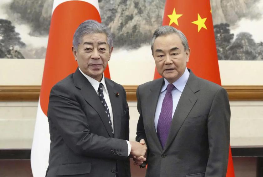 ဒီဇင်ဘာ ၂၆ ရက်က ပေကျင်းမြို့တော်ရှိ Diaoyutai နိုင်ငံတော် ဧည့်ဂေဟာတွင် လက်ဆွဲနှုတ်ဆက်နေသည့် အီဝါယာ (ဝဲ) နှင့် ဝမ်ယိတို့ကို တွေ့ရစဉ်(Photo: AP)