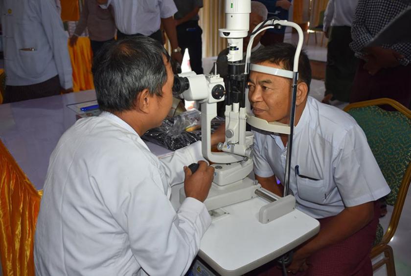   ကမ္ဘာ့မျက်မမြင်ပပျောက်ရေးနေ့အခမ်းအနားသို့ တက်ရောက်လာသူတစ်ဦးအား မျက်စိစမ်းသပ်နေစဉ်